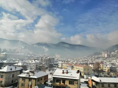 a city with buildings and mountains in the background at Апартамент Легал in Chepelare