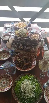 a table with many plates of food on it at Guest House Markovi in Govedartsi