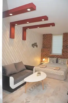a bedroom with a bed and a couch and a table at IFM Boutique studio in Plovdiv