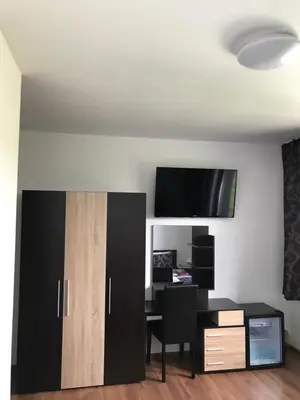 a living room with a desk and a tv on a wall at КЪЩА ЗА ГОСТИ ХАРМОНИ in Shiroki Dol