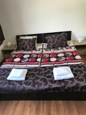 a bed with two pillows and two towels on it at КЪЩА ЗА ГОСТИ ХАРМОНИ in Shiroki Dol
