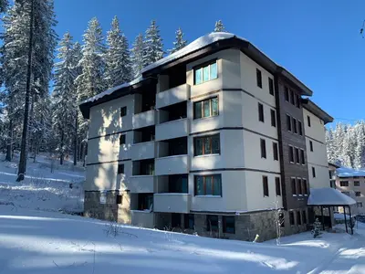 a apartment building in the snow in the woods at Evrika home 5 in Pamporovo