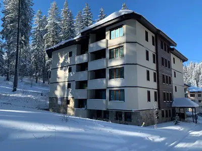 a apartment building in the snow in the woods at Evrika home 21 in Pamporovo