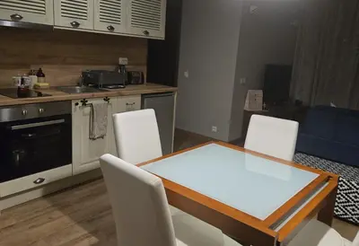 a kitchen with a table and chairs in a kitchen at Apartment at White Lavina Hotel in Bansko