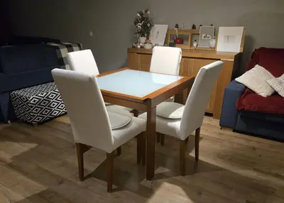 a dining room table with four white chairs around it at Apartment at White Lavina Hotel in Bansko