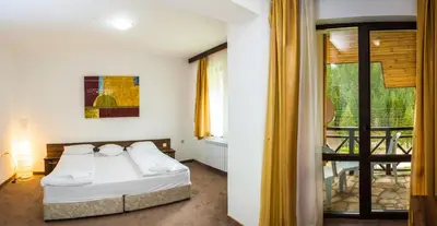 a bedroom with a bed and a balcony at Boriki Complex in Pamporovo