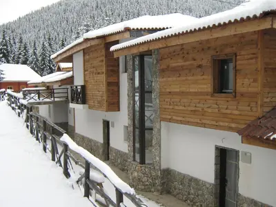 a building covered in snow with a fence at Boriki Complex in Pamporovo