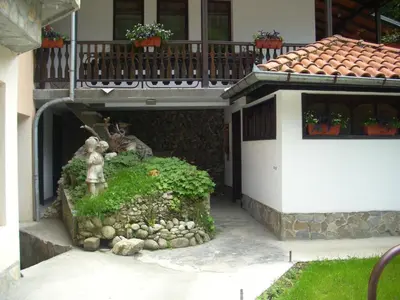 a small house with a statue under a balcony at Blyan Family Hotel in Chiflik