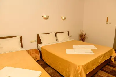 two beds in a small room with towels on the bed at Blyan Family Hotel in Chiflik