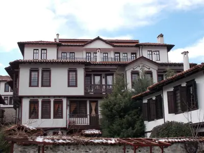 a large white house with black shutters at Апартхотел 
