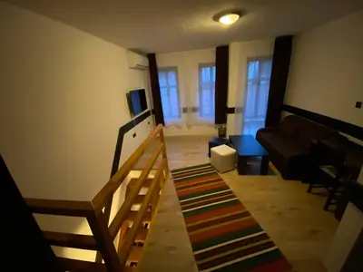 a living room with a staircase and a couch at Апартхотел 