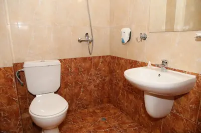 a bathroom with a toilet and a sink at Family Prim Hotel in Sandanski