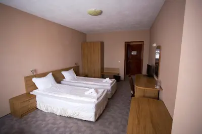 a hotel room with two beds and a television at Family Prim Hotel in Sandanski