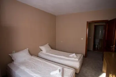 a room with two beds in a room with a window at Family Prim Hotel in Sandanski