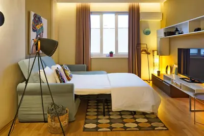 a room with a bed and a couch and a television at Apartment Memoir by SofiaSpot - central, metro to airport in Sofia