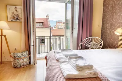 a bedroom with a bed and a large window at Apartment Memoir by SofiaSpot - central, metro to airport in Sofia