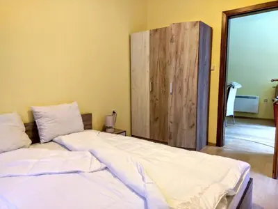 a bedroom with a bed and a wooden cabinet at Private Apartments Nevena in Pamporovo