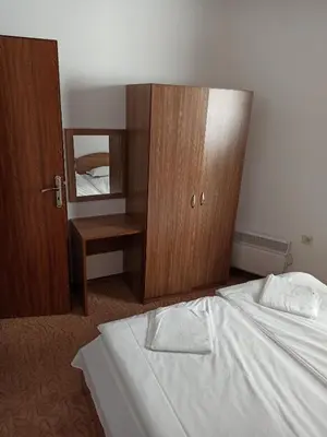 a bedroom with a bed and a dresser and a mirror at Private Apartments Nevena in Pamporovo