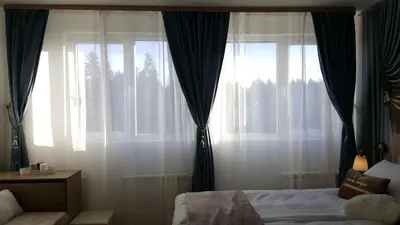 a bedroom with a bed and two large windows at Apartment 15 in Borovets