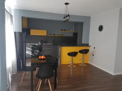 a kitchen with a table and chairs in a room at LUXURY SUITES in Karlovo