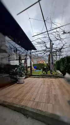 a wooden deck with a potted tree on it at Стаи за гости Върбите in Sapareva Banya