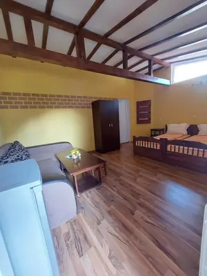 a living room with two beds and a table at Стаи за гости Върбите in Sapareva Banya