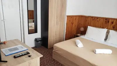 a hotel room with a bed and a desk with a telephone at Guest Rooms- KLEPALSKI House in Borovets
