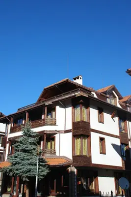 an apartment building with a tree in front of it at Guest House ANEX in Bansko