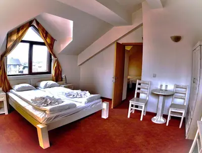 a bedroom with a bed and a table and chairs at Guest House ANEX in Bansko