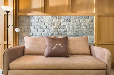 a couch with two pillows on it with a brick wall at Hotel and Relax Moreni in Sofia