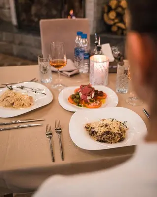 a table with plates of food and glasses of wine at Hotel and Relax Moreni in Sofia