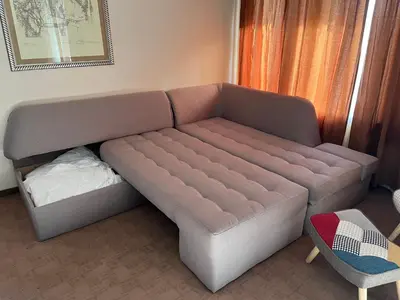 a large couch with a bed in a room at Mountain View Apartment in Bansko