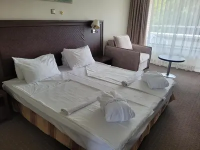 a large bed in a hotel room with towels on it at Sana Spa Hotel in Hisarya
