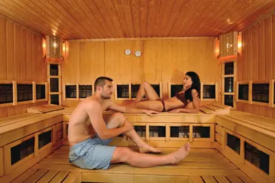 a man and a woman sitting in a sauna at Sana Spa Hotel in Hisarya