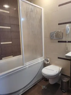 a bathroom with a toilet and a shower and a sink at Sana Spa Hotel in Hisarya