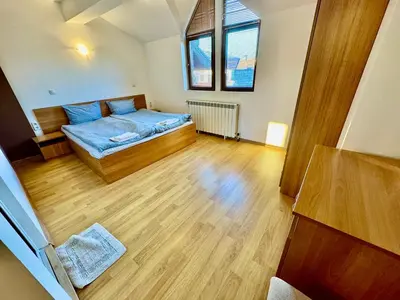 a bedroom with a bed and a wooden floor at TM HOUSE - Private Rooms in Bansko
