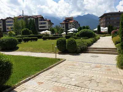 a walkway through a park with bushes and buildings at Private Studio in Aspen Golf and Ski Resort in Razlog