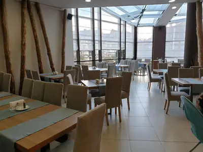 a dining room with tables and chairs and windows at Private Studio in Aspen Golf and Ski Resort in Razlog
