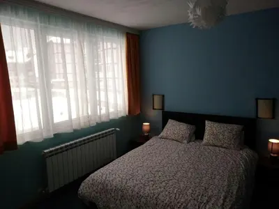 a blue bedroom with a bed and two windows at Borovets Apartments, Iglika 2 in Borovets