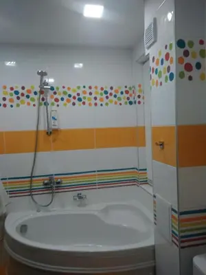 a bathroom with a tub and a shower with colorful walls at Borovets Apartments, Iglika 2 in Borovets