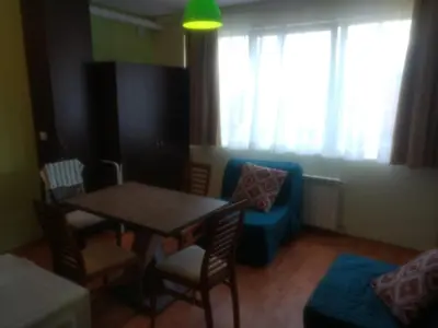 a living room with a table and a blue couch at Borovets Apartments, Iglika 2 in Borovets