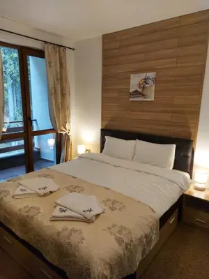 a bedroom with a large bed with two towels on it at Апартамент Winter home Iceberg in Pamporovo