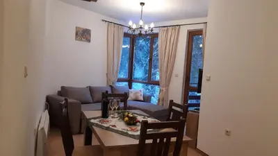 a living room with a table and a couch at Апартамент Winter home Iceberg in Pamporovo
