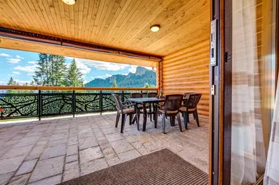 a patio with a table and chairs on a balcony at Вила Морава in Pamporovo
