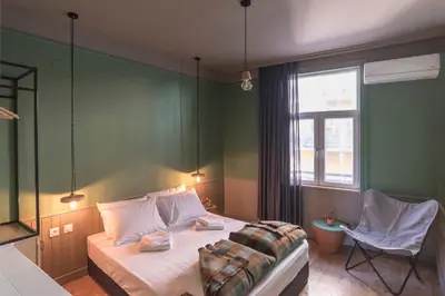 a bedroom with a bed and a chair and a window at Beautiful best location apartment Green Mouse in Plovdiv