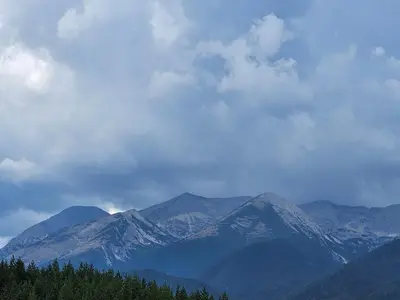 a view of a mountain range with trees in the foreground at Emerald Buddha Apartment in Bansko