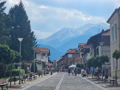 a cobblestone street with a mountain in the background at Emerald Buddha Apartment in Bansko
