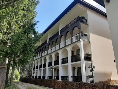 a large white building with balconies and a fence at Апартамент КАРЛИН in Pamporovo