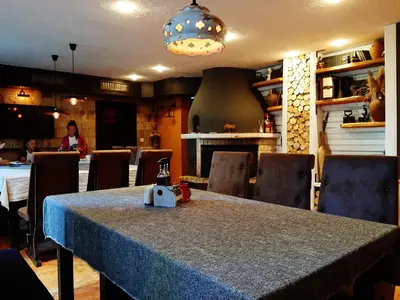a dining room with a table in a restaurant at Апартамент КАРЛИН in Pamporovo