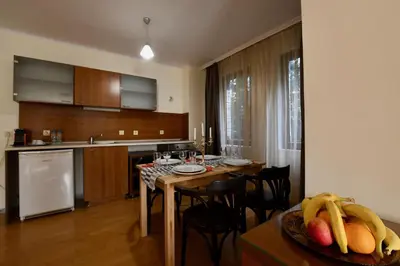 a kitchen and dining room with a table and chairs at Dolomiti Apartments in Bansko